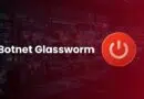 Cybersecurity banner: 'Botnet Glassworm' text with a red circular power icon on the right in a dark network operations center/screen wall.