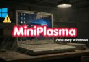Old, cracked laptop on a wooden desk in a dark workshop, with a bold 'MiniPlasma' title and 'Zero-Day Windows' subtitle; warning icon nearby.