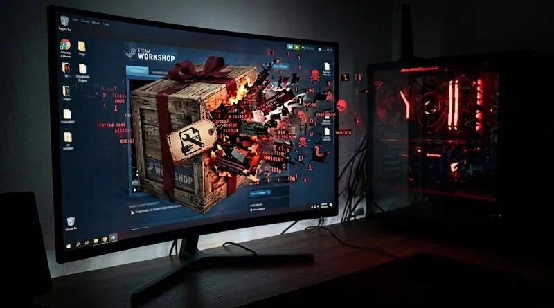 Gaming setup with a curved monitor showing a Steam Workshop splash and a crate exploding on screen, plus a red-lit PC tower to the right