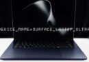 Laptop with a display showing 'DEVICE_NAME=SURFACE_LAPTOP_ULTRA' on a dark screen.