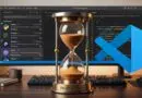 Hourglass on a desk in front of a monitor displaying VS Code and code, symbolizing a 2-hour delay