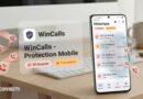 Mobile security app WinCalls Protection Mobile blocking spam calls, with history screen on a smartphone beside a laptop on a desk