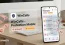 Mobile security app WinCalls Protection Mobile blocking spam calls, with history screen on a smartphone beside a laptop on a desk