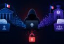 Hooded hacker typing on a laptop with a skull, flanked by blue government-style buildings and data folders, a glowing red lock below.