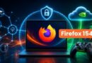 Laptop shows Firefox logo with a prominent Firefox 154 badge, surrounded by cloud and shield/security icons, plus a gaming controller in the foreground.